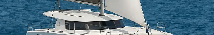 White catamaran cruising on turquoise water with islands in the distance—your dream sailing adventure checklist starts here.